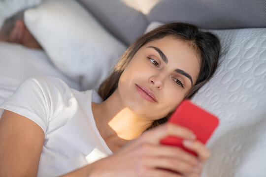 Woman using a smartphone in a bed