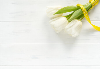 White tulips bouquet on a white background. Spring flowers background top view. Banner with copy space