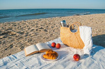 Summer picnic on the beach by the sea at a sunrise.