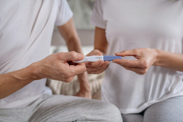 Woman sharing her pregnancy test results with her husband