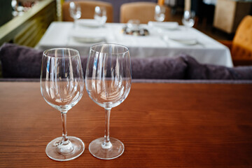 two empty clean wine glasses on a wooden table. utensils for alcoholic beverages. serving the table.