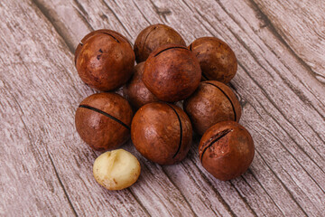 Brown macadamia nut heap over background