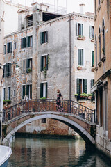Fototapeta na wymiar The girl walks through the narrow streets. A tourist travels around Venice.
