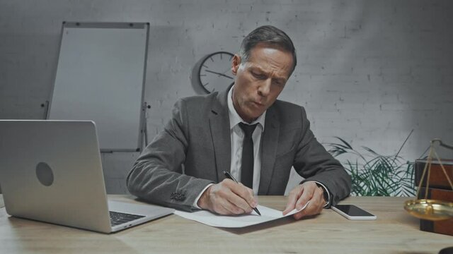 Angry lawyer tearing and throwing paper in office