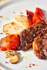 Hot Rib eye steak on white plate. Garnish grilled vegetables. Barbecue restaurant menu.