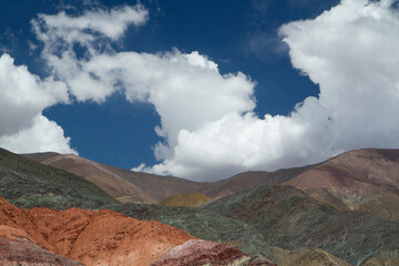 The colorful hills under a dramatic sky. Aerial view of the beautiful Andes mountains in Purmamarca, Jujuy, Argentina. The beautiful minerals  colors and rock textures and patterns.