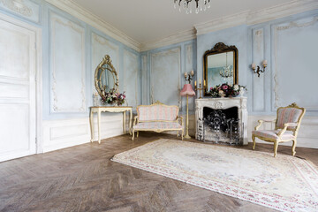 cozy living room interior with chic beautiful antique baroque furniture, walls are decorated with stucco and wooden parquet. daytime warm soft light.