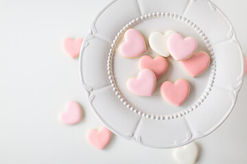 pink heart sugar cookies on white decorative plate, offset