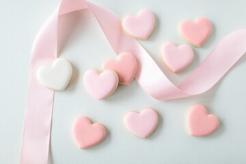 pink heart sugar cookies on white background with pink ribbon