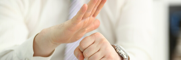 Close up of manager male hands showing gesture of aggression while sitting at the table