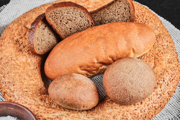 Various types homemade bread on dark table with white tablecloth