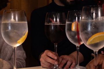 a close-up of young friends toasting with their glasses tropical background