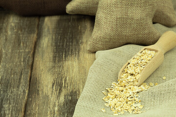Oatmeal in a bag on a wooden background with space for text