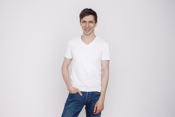 Portrait of smiling young man in a white t-shirt isolated on white background.