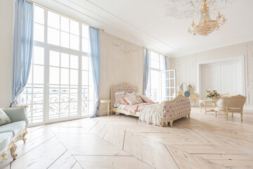 luxurious light interior in the Baroque style. A spacious room with a road chic beautiful furniture, a fireplace and flowers. plant stucco on the walls and light wood parquet