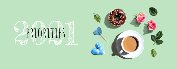 Priorities 2021 concept with a cup of coffee and a donut - flat lay