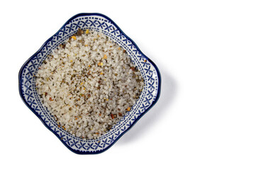 Spices, white, black and red peppers, sea salt on ornamental plate on a white background, close-up, isolated