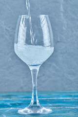 A glass of sparkling water on blue background