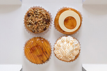 Four beautiful pastries in a cardboard box from above. 