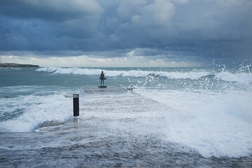 Statue of a young fisherman in the waves