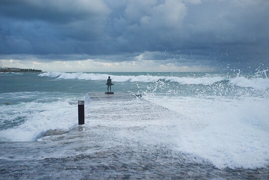 Statue of a young fisherman in the waves