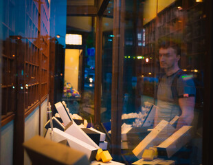The guy stands behind the glass and looks at the shop window