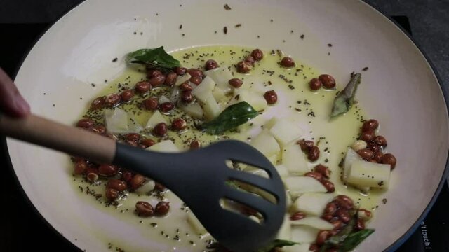 A video of roasting Chopped potatoes with peanuts for making Poha.