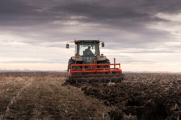 Tractor on the field during sunset.