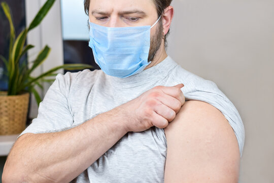 Bearded man wearing blue protective mask getting ready to be vaccinated. Covid-19 vaccination campaign.