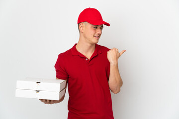 Pizza delivery man with work uniform picking up pizza boxes isolated on white background pointing...