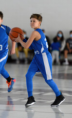 Fototapeta premium Young athletic boy playing in a game of basketball