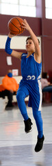 Young athletic boy playing in a game of basketball