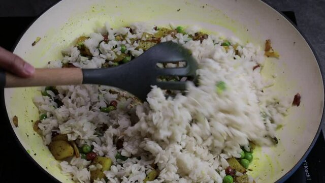 Cooking Batata and Kanda Poha or Potato, Onion Poha, a Maharashtrian snack dish.
