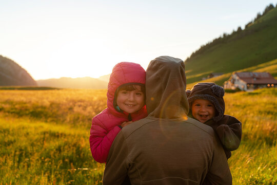 Smiling children with their mother at sunset during vacations at Col Des Aravis, Haute-savoie, France