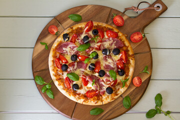 Delicious pizza served on wooden pizza board, french fries. View from above, top view