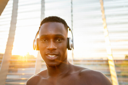 Sportsman with headphones on sunny day