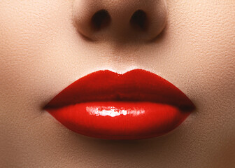 Closeup shot of beautiful full lips with red glossy make-up. Perfect bright lipstick. Plastic surgery or makeup concept