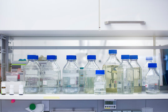 Liquid solution bottles on shelf in laboratory