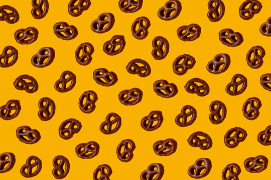 Pattern of chocolate pretzels&not;&dagger;against yellow background