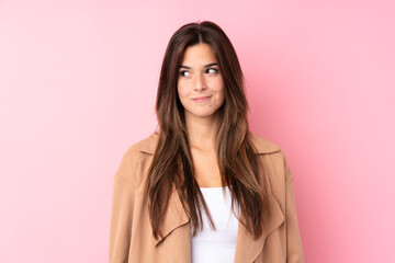 Teenager Brazilian girl over isolated pink background standing and looking to the side