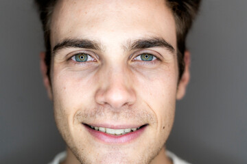 Smiling young male influencer against gray background