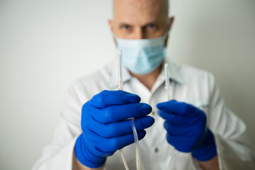 a needle from a dropper in the hands of a doctor close up. 