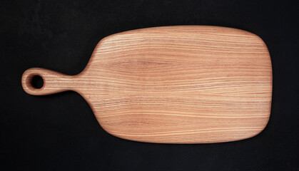 Wooden kitchen board on a black background.