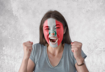 Young woman with painted flag of Peru and open mouth looking energetic with fists up