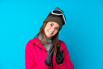 Teenager skier girl with snowboarding glasses over isolated blue background applauding