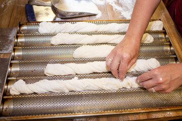 Bread baking process. Woman working with dough. forming a baguette - French roll