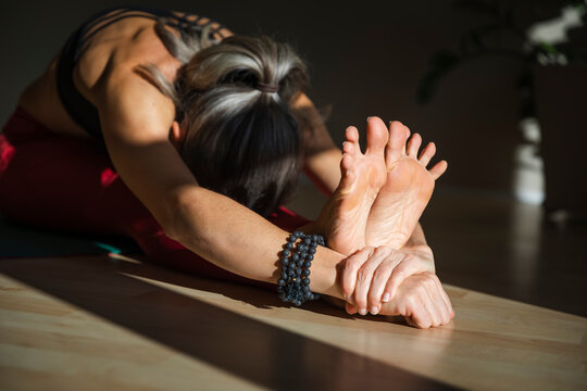 Yogini stretching at home on sunny day