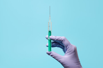 Syringe for injection in hand, latex medical gloves on hand. On a blue background.