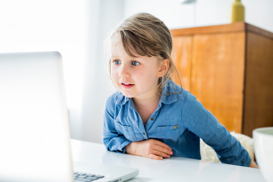 Girl looking at laptop while sitting at home