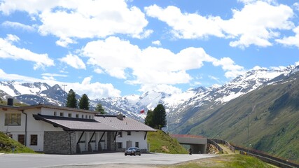 Mountainous landscape with freshly snow covered steppe-like botany partly wooded wide view into the country on which a road leads